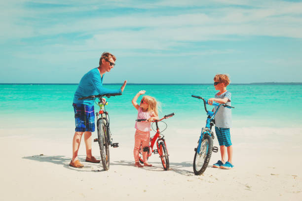 istock father with little son and daughter biking on beach 922853052