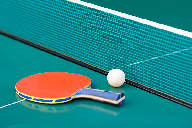Ping pong paddle and table with net stock photo