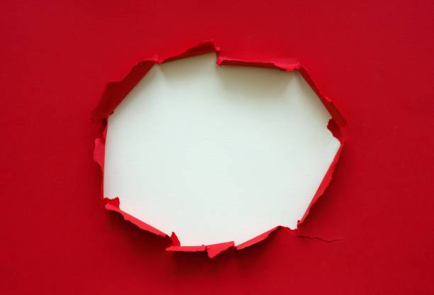 istock Wrinkle ripped torn red paper with hole in center poster backdrop empty space 922858210