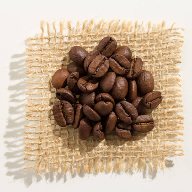 close-up of coffee beans on jute against white background - 7109 imagens e fotografias de stock