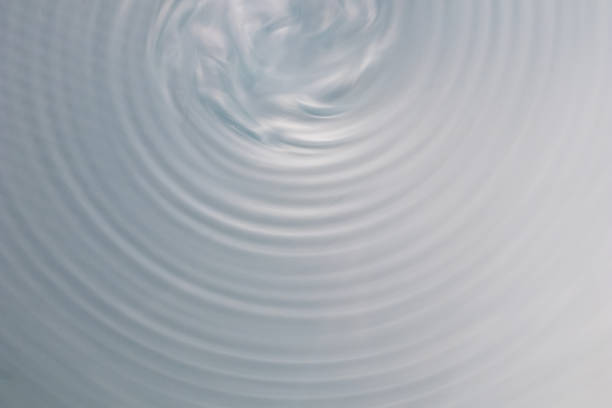 istock circular wave motion in a fluid system. blue gray background for a liquid pushed into a circular motion. 922861576