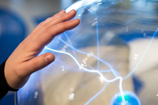 Electric sphere produce plasma with blue sparks and bolt. Science education experiment with electricity and plasma ball. stock photo