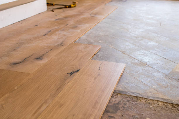 istock Oak colored parquet during installation on an old stoneware floor near an open window. 922864514
