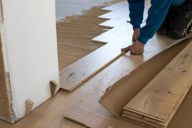 istock Renovation of an apartment, skilled worker uses a plastic hammer when installing pre-finished interlocking parquet. 922864662