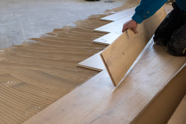 istock Renovation of an apartment, skilled worker uses a plastic hammer when installing pre-finished interlocking parquet. 922864668