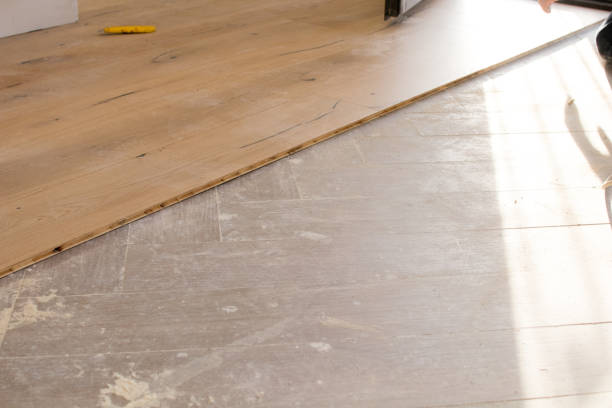 istock Oak colored parquet during installation on an old stoneware floor near an open window. 922864740
