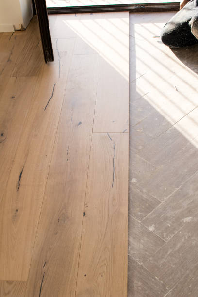 istock Oak colored parquet during installation on an old stoneware floor near an open window. 922864760