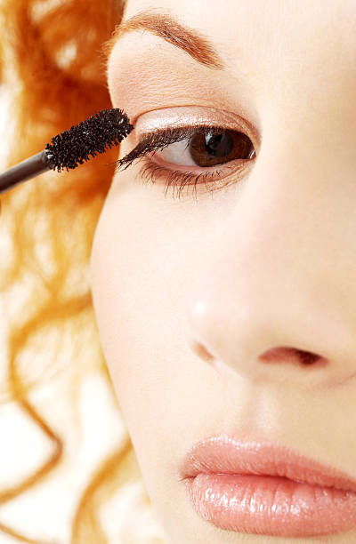 istock lovely redhead applying black mascara 92286660