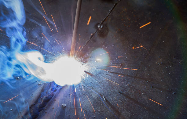 SMAW – Shielded metal arc welding. SMAW – Shielded metal arc welding and welding flame at spark  point. welder engineering construction bright stock pictures, royalty-free photos & images