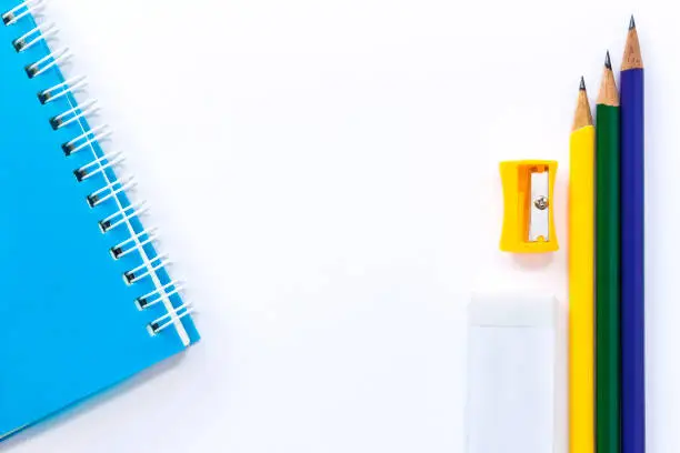 pencil-sharpener, eraser, notebook, and pencil isolated on white table background. with copy space for your text.