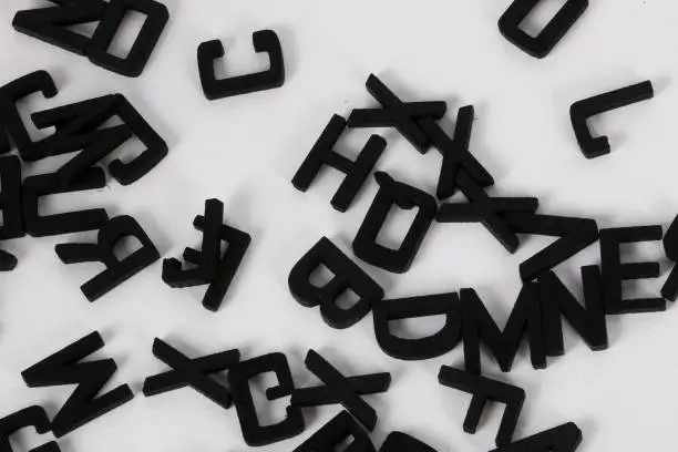 black wooden letters lie on a pile in the studio