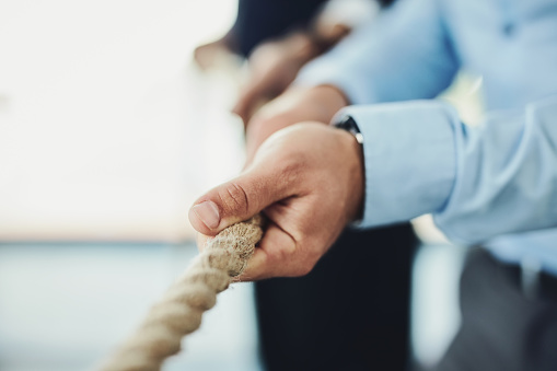 Closeup shot of unrecognizable businesspeople pulling on a rope