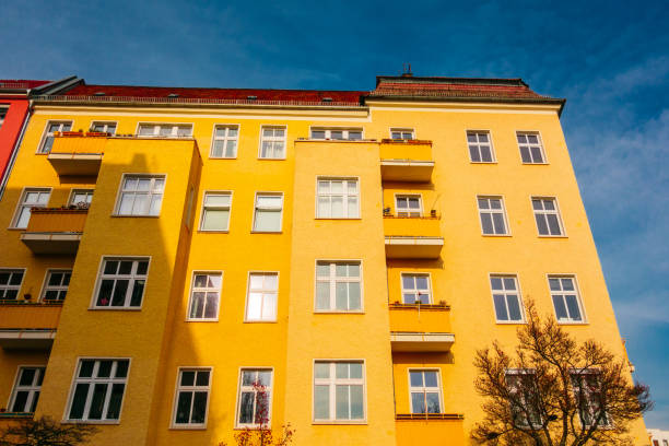 istock yellow colored apartment house with darken sky 922887168