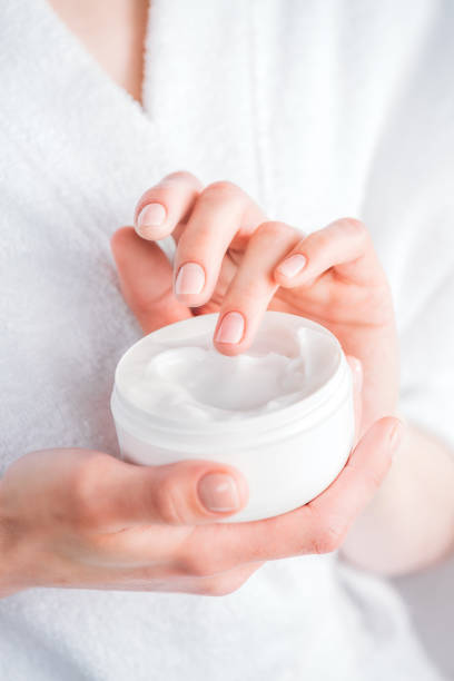 istock woman holding face cream jar 922890184