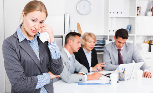 istock Business woman crying in office with working colleagues 922890738