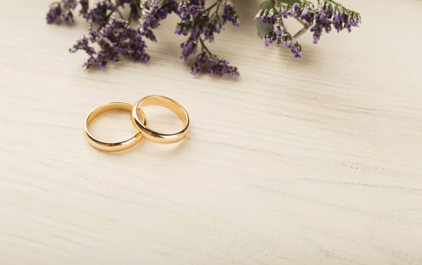 istock Two golden wedding rings with flower decorations 922890806