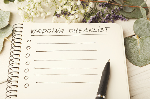 Wedding checklist with copy space and cute flowers on the white desktop. Marriage planner concept, copy space.