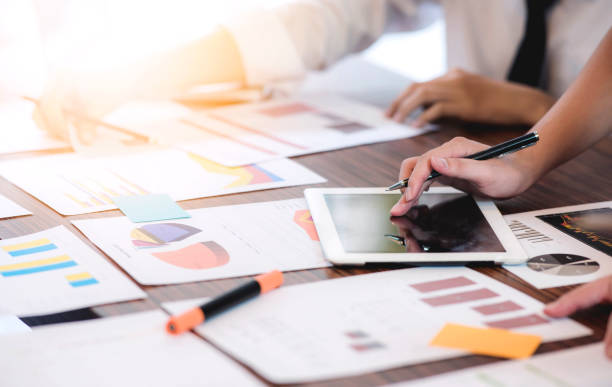 istock Image of busiess people discussing business documents on tablet at meeting 922890988