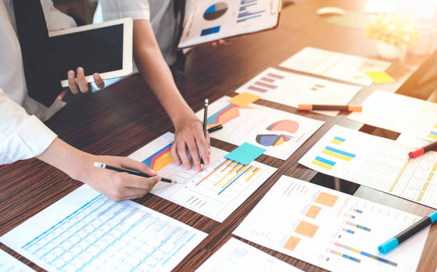istock Image of busiess people discussing business documents at meeting with sunlight 922894500