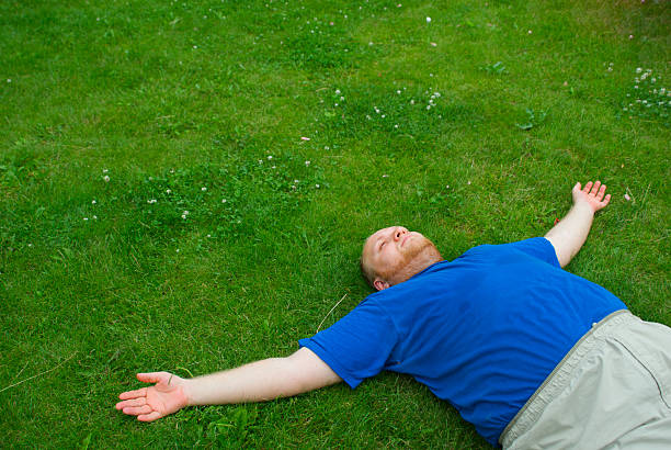 Men laying on green grass stock photo