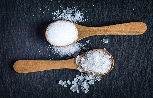 Diferentes tipos de sal. Vista superior de dos cucharas de madera photo