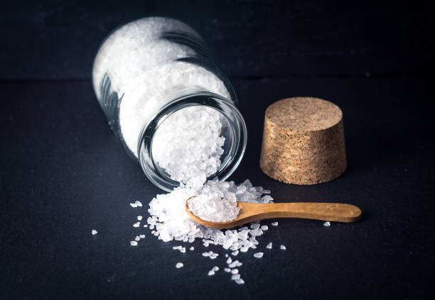 istock Sea salt with spoon and jar on dark background 922902446