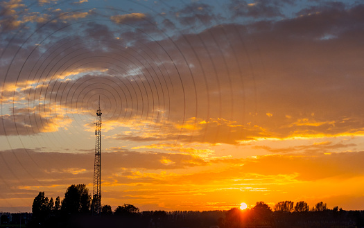 Radio waves escaping from gsm tower   visualisation at sunset in rural area