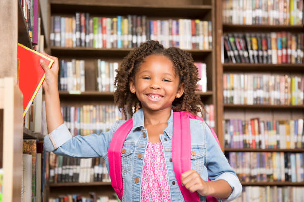 istock African descent little girl in school library choosing book. 922913384