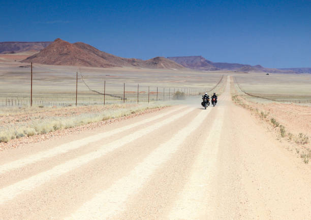 まっすぐ長い砂漠の道路で運転する 2 台のバイクが高速です。 - two lane highway 写真 ストックフォトと画像
