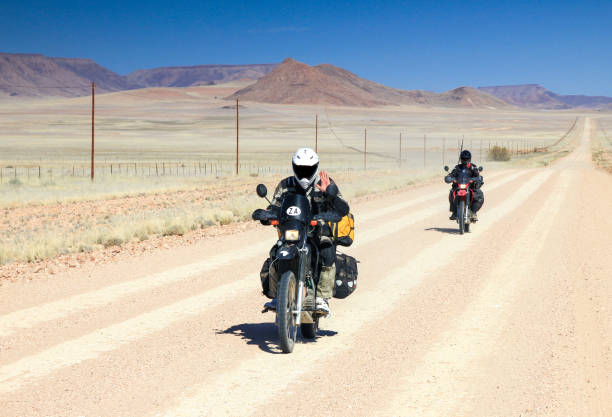 まっすぐ長い砂漠の道路で運転する 2 台のバイクが高速です。 - two lane highway 写真 ストックフォトと画像