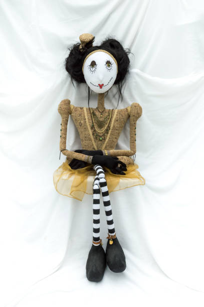 istock Creepy steampunk doll sitting facing forward. Legs crossed. Vertical. 922919576
