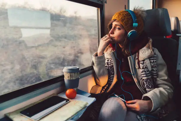 Thoughtful woman in the train looking through the window