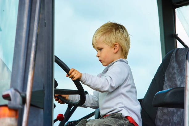 istock Little blond boy in tractor, outdoors 922933254