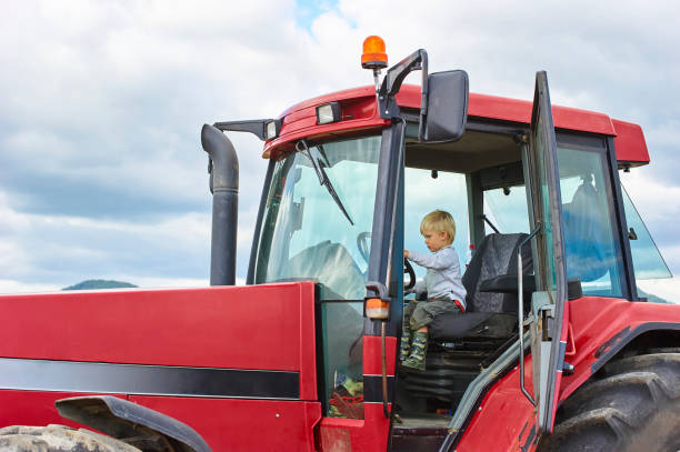 istock Little blond boy in tractor, outdoors 922933364