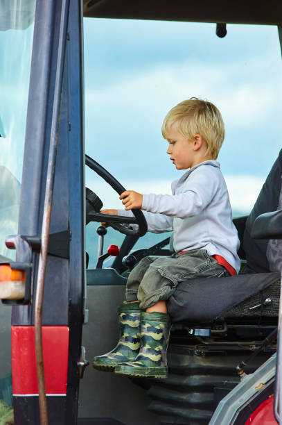 istock Little blond boy in tractor, outdoors 922933404
