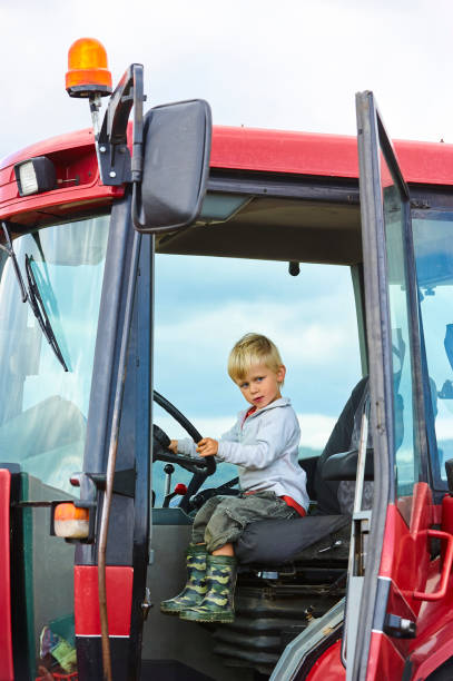 istock Little blond boy in tractor, outdoors 922933408