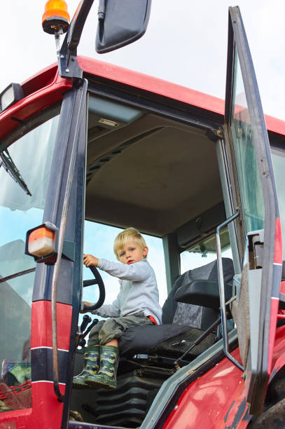 istock Little blond boy in tractor, outdoors 922933520