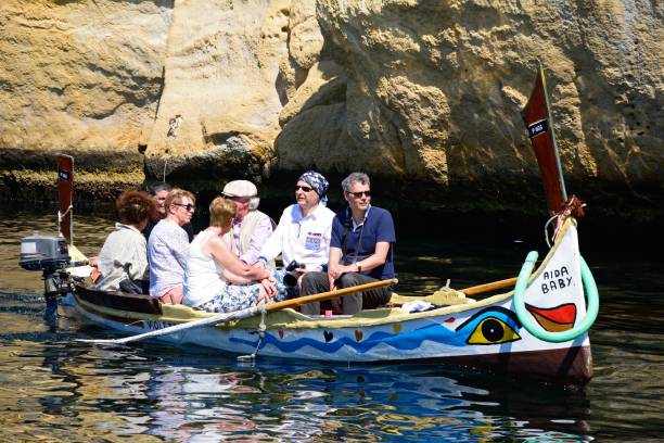 Tourists on a Dghajsa water taxi, Malta. Passengers on board a traditional Maltese Dghajsa water taxi in an inlet alongside Fort San Angelo, Vittoriosa, Malta, Europe. coconut crab stock pictures, royalty-free photos & images