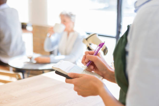 istock Unrecognizable coffee shop waitress writes in order pad 922939822
