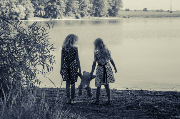 istock two blond girls sisters playing together 922942438