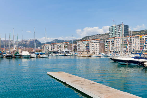 Harbor of Toulon, France Harbor of Toulon with a row of buildings and mountain range in the background provence alpes cote dazur stock pictures, royalty-free photos & images