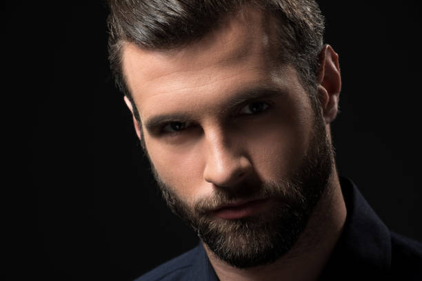 istock portrait of confident bearded man looking at camera isolated on black 922947498