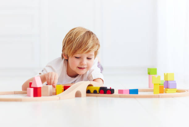 istock cute kid playing with toy railway at home 922950226