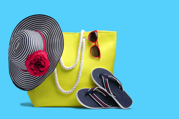 Beach bag, hat and other beach stuff  on blue background.