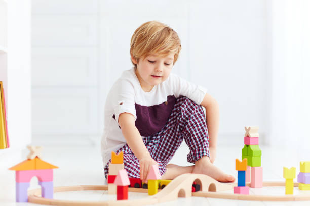 istock cute kid playing with toy railway at home 922950896