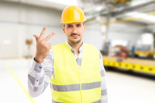 istock Handsome young factory worker or engineer showing number three 922951074