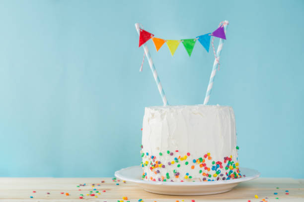 istock Birthday background - striped rainbow cake with white frosting 922953768