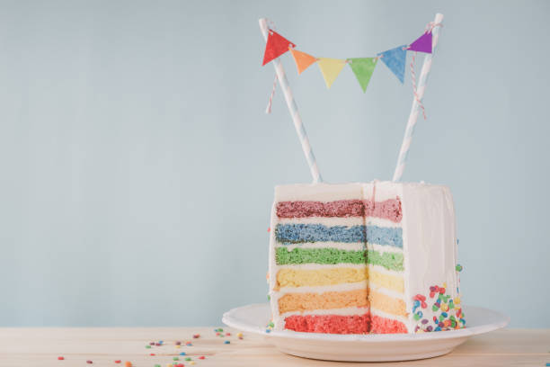 istock Birthday background - striped rainbow cake with white frosting 922953850