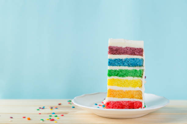 istock Birthday background - striped rainbow cake with white frosting 922953872