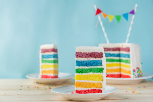istock Birthday background - striped rainbow cake with white frosting 922953910